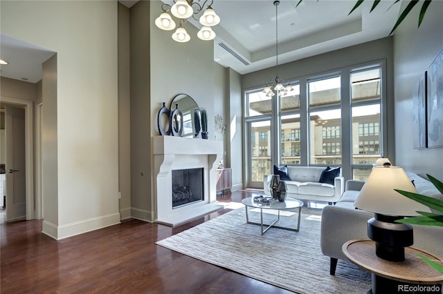 5455 Landmark Pl Unit 1403, Greenwood Village, CO 80111 - living room with a chandelier, wood finished floors, a fireplace with raised hearth, baseboards, and a high ceiling