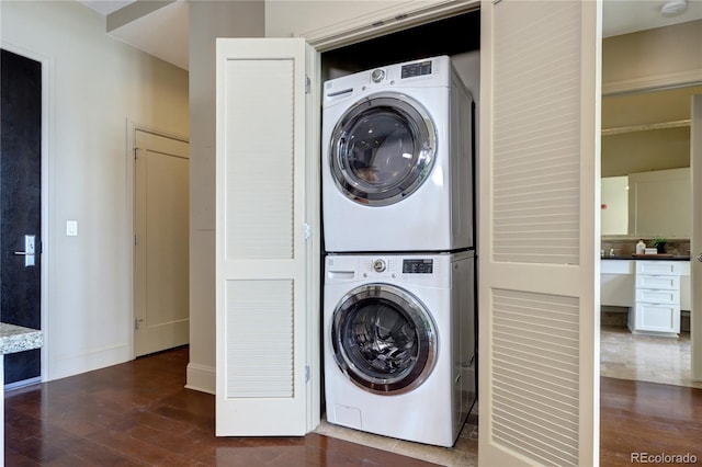 5455 Landmark Pl Unit 1403, Greenwood Village, CO 80111 - washroom with stacked washer / drying machine, dark wood-style floors, and baseboards