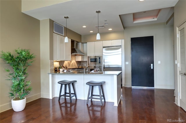 5455 Landmark Pl Unit 1403, Greenwood Village, CO 80111 - kitchen with built in appliances, wall chimney exhaust hood, stone countertops, a peninsula, and baseboards