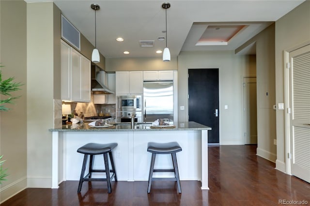 5455 Landmark Pl Unit 1403, Greenwood Village, CO 80111 - kitchen with stainless steel appliances, wall chimney exhaust hood, stone counters, a peninsula, and recessed lighting