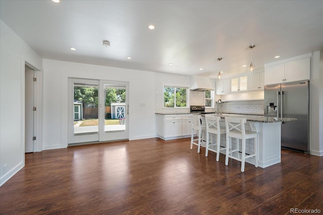 3324 W Hialeah Ave, Littleton, CO 80123 - kitchen featuring appliances with stainless steel finishes, custom range hood, a kitchen island, a kitchen breakfast bar, and decorative backsplash