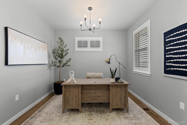 office area with visible vents, an inviting chandelier, baseboards, and wood finished floors