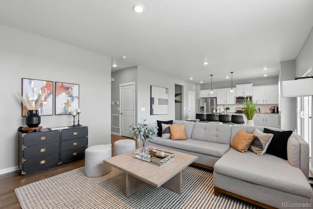 living room featuring recessed lighting, baseboards, and dark wood-style floors