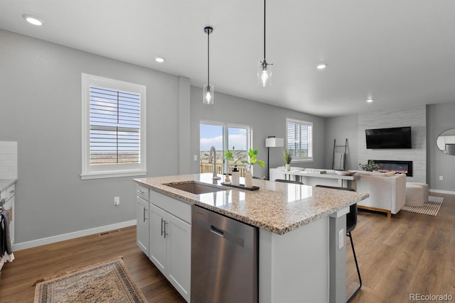 kitchen with dark wood-style floors, dishwasher, a fireplace, and a sink