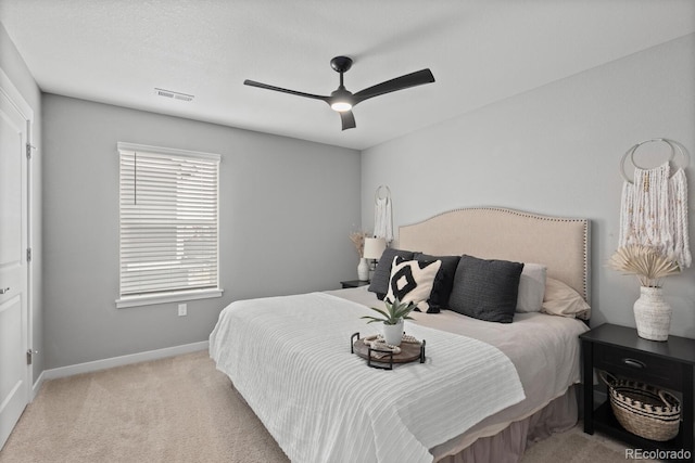 bedroom with visible vents, light carpet, baseboards, and ceiling fan