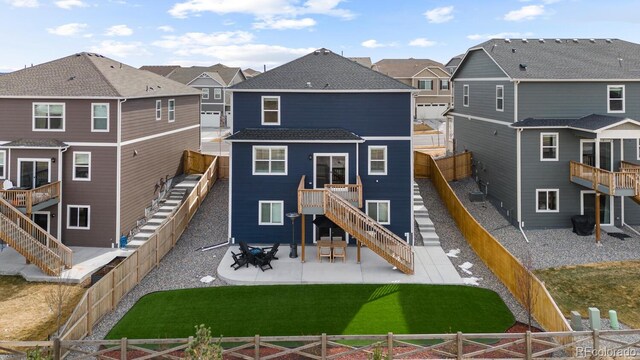 back of property with stairs, a fenced backyard, and a residential view