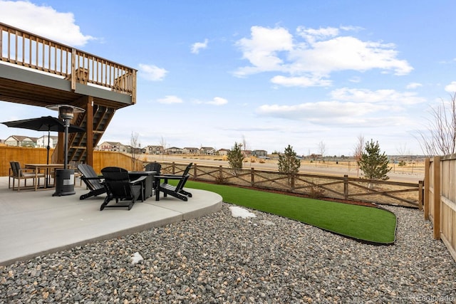 view of yard with a patio, a fenced backyard, and stairs