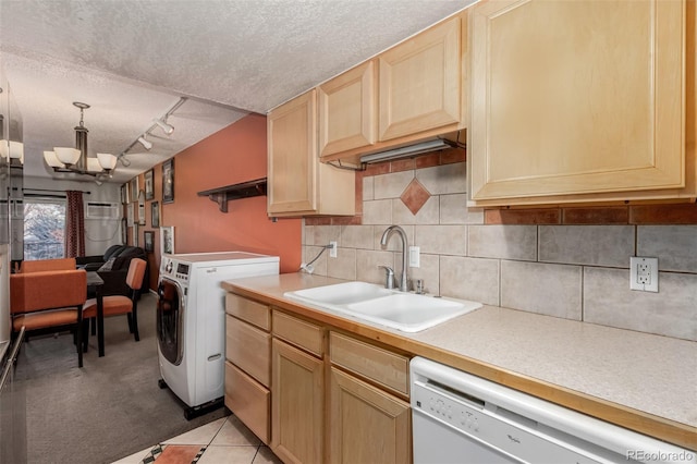 clothes washing area with sink, an inviting chandelier, washer / dryer, track lighting, and a textured ceiling