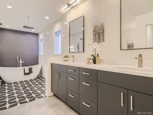 full bath with double vanity, tile walls, a freestanding tub, tiled shower, and tile patterned floors