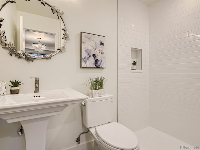 bathroom featuring toilet, a chandelier, and tiled shower