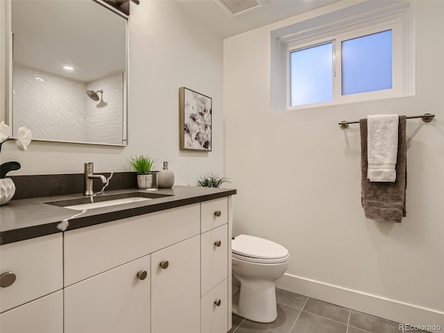 bathroom featuring tile patterned flooring, vanity, toilet, baseboards, and a shower