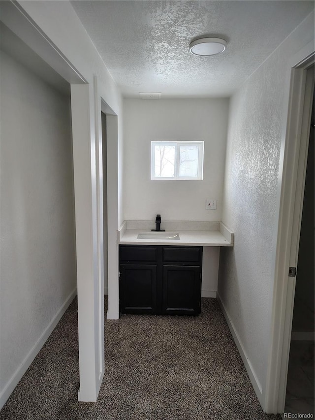 1045 Macdavidson Cir, Dacono, CO 80514 - bar with a sink, dark colored carpet, a textured ceiling, and baseboards