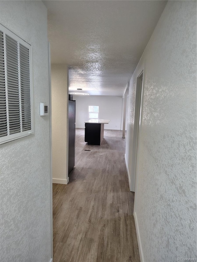 1045 Macdavidson Cir, Dacono, CO 80514 - corridor featuring a textured wall, wood finished floors, baseboards, and a textured ceiling