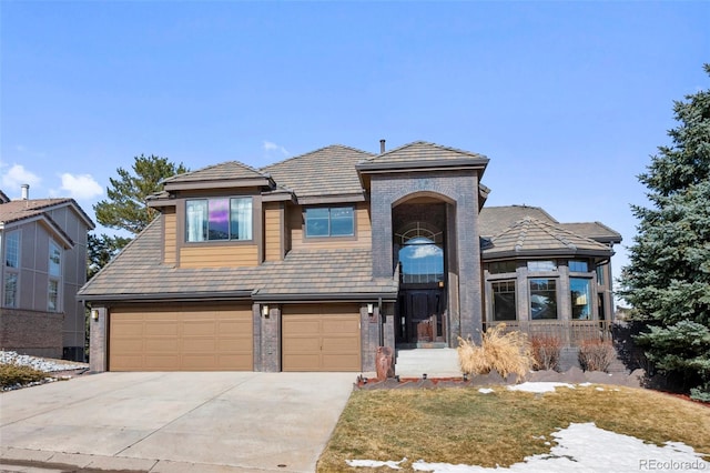 view of front of home featuring a garage, brick siding, and driveway