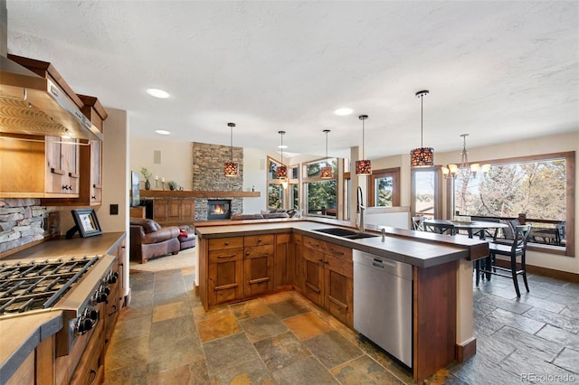 34 Amaranth Dr, Littleton, CO 80127 - kitchen with a sink, brown cabinets, stone tile flooring, a fireplace, and appliances with stainless steel finishes
