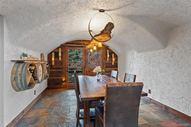 34 Amaranth Dr, Littleton, CO 80127 - dining area featuring a textured ceiling, lofted ceiling, stone tile floors, and baseboards
