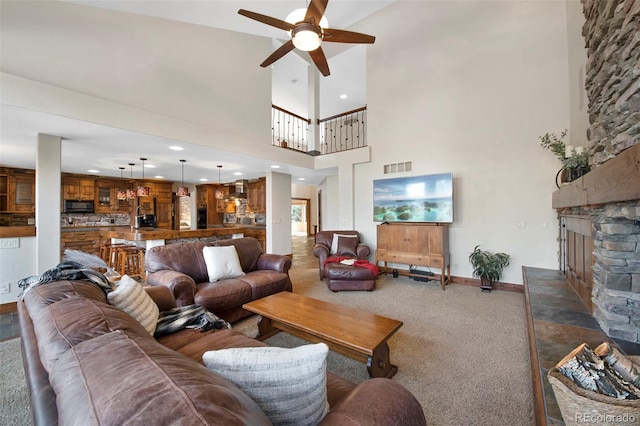 34 Amaranth Dr, Littleton, CO 80127 - living area featuring a ceiling fan, carpet floors, a fireplace, a high ceiling, and visible vents