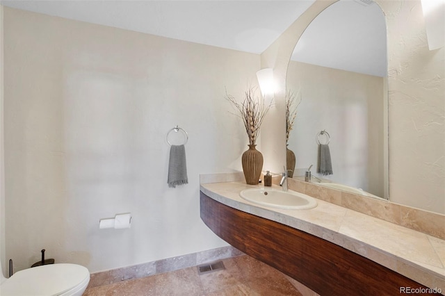 34 Amaranth Dr, Littleton, CO 80127 - bathroom with toilet, vanity, visible vents, and baseboards