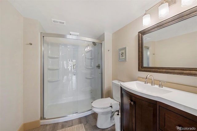 34 Amaranth Dr, Littleton, CO 80127 - bathroom with wood finished floors, a stall shower, vanity, toilet, and visible vents