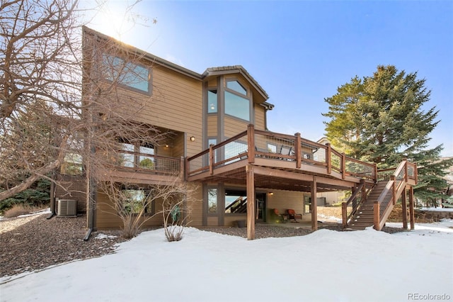 34 Amaranth Dr, Littleton, CO 80127 - snow covered back of property with stairway, a wooden deck, cooling unit, and a patio