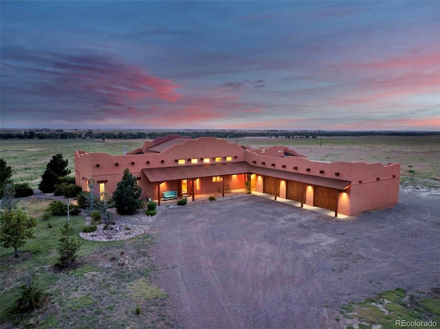 5549 Yulle Rd, Bennett, CO 80102 - adobe home featuring driveway, an attached garage, and stucco siding