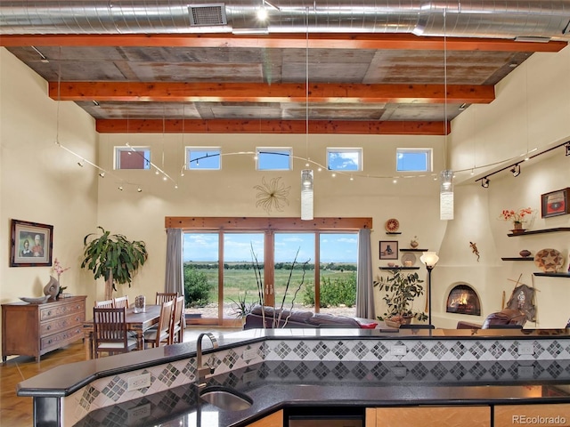 5549 Yulle Rd, Bennett, CO 80102 - kitchen with dark countertops, beam ceiling, a high ceiling, plenty of natural light, and open floor plan