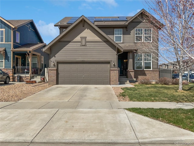 1826 Sunshine Ave, Longmont, CO 80504 - view of front of house with brick siding, a front lawn, concrete driveway, and roof mounted solar panels