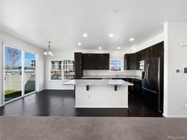 1826 Sunshine Ave, Longmont, CO 80504 - kitchen with stainless steel appliances, a kitchen island, a breakfast bar, a chandelier, and recessed lighting