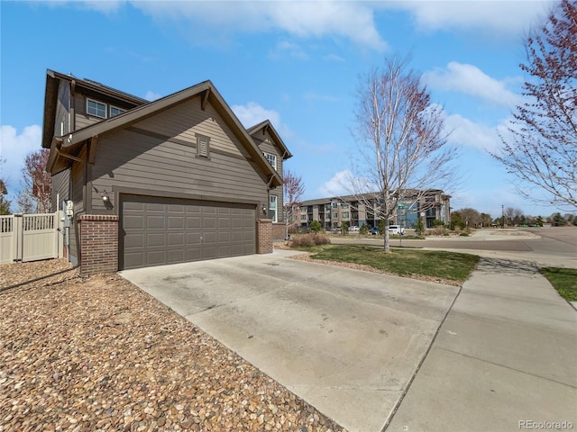 1826 Sunshine Ave, Longmont, CO 80504 - view of property exterior featuring brick siding, driveway, a gate, and an attached garage