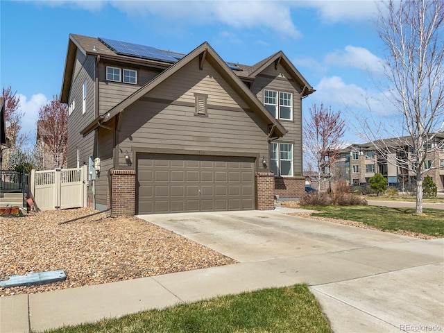 1826 Sunshine Ave, Longmont, CO 80504 - traditional-style home featuring brick siding, roof mounted solar panels, driveway, a garage, and a gate