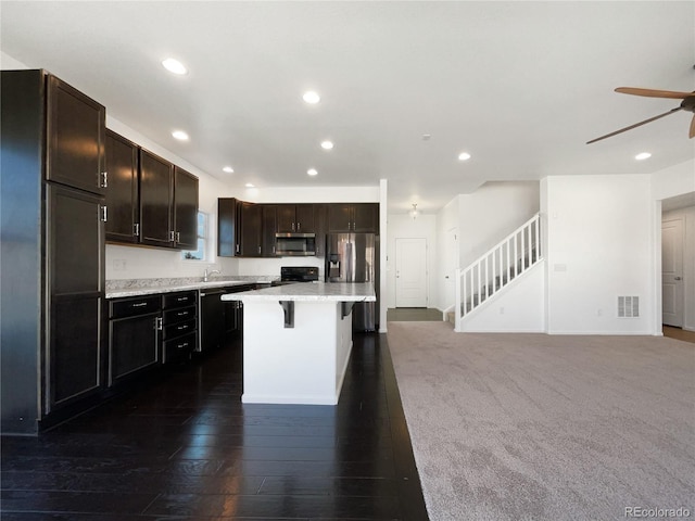 1826 Sunshine Ave, Longmont, CO 80504 - kitchen with stainless steel appliances, recessed lighting, light countertops, a kitchen breakfast bar, and ceiling fan