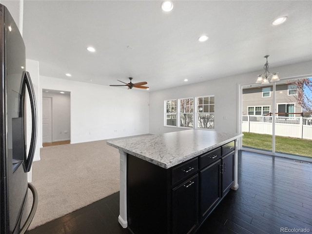 1826 Sunshine Ave, Longmont, CO 80504 - kitchen with freestanding refrigerator, recessed lighting, dark cabinetry, ceiling fan, and light countertops