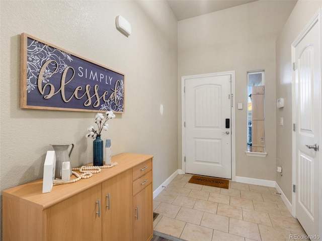 entrance foyer with light tile patterned floors and baseboards