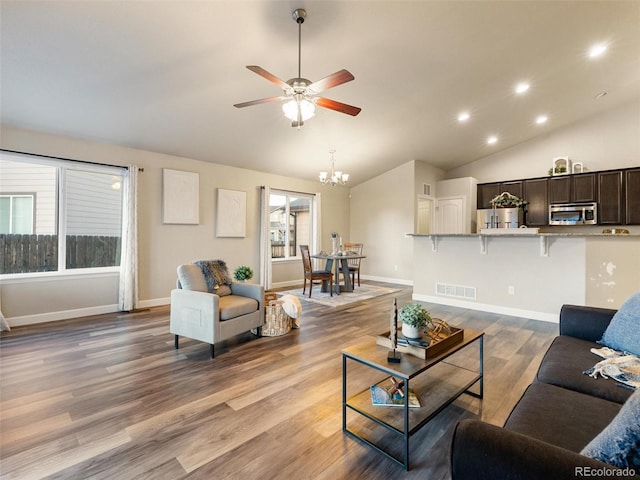 living area with lofted ceiling, a wealth of natural light, baseboards, and wood finished floors