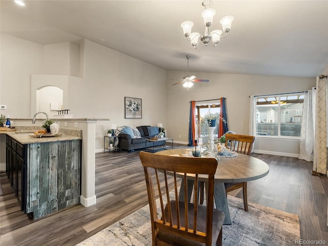 dining space with dark wood-style flooring, vaulted ceiling, baseboards, and ceiling fan with notable chandelier