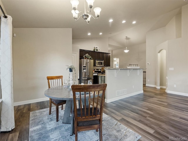 dining area with arched walkways, dark wood finished floors, recessed lighting, visible vents, and vaulted ceiling