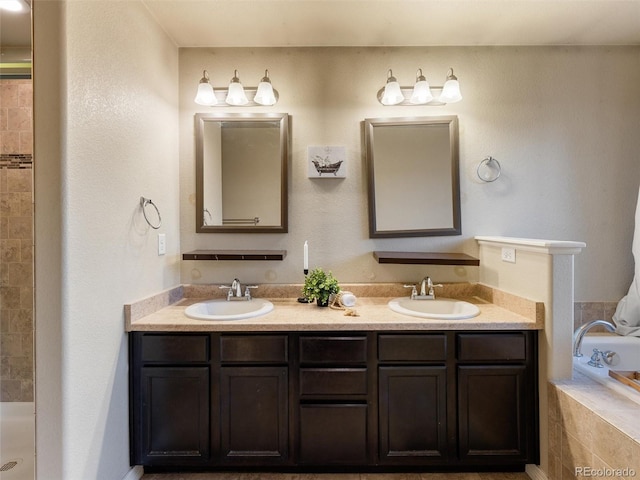 bathroom featuring a relaxing tiled tub, tiled shower, a sink, and double vanity