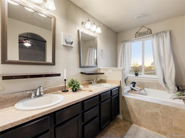 full bath featuring a relaxing tiled tub, tile patterned flooring, a sink, and double vanity