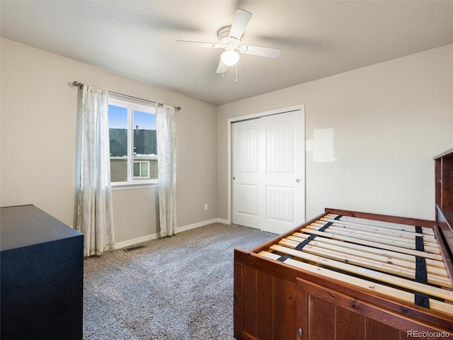 carpeted bedroom featuring a ceiling fan, a closet, visible vents, and baseboards