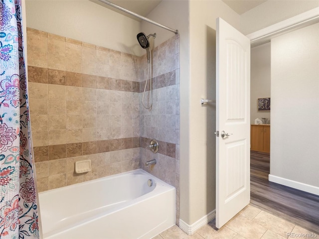 full bath featuring tile patterned flooring, baseboards, and shower / bath combo with shower curtain