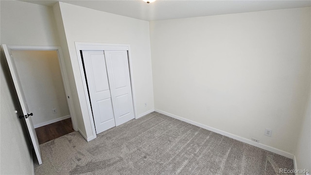 unfurnished bedroom with carpet, baseboards, and a closet