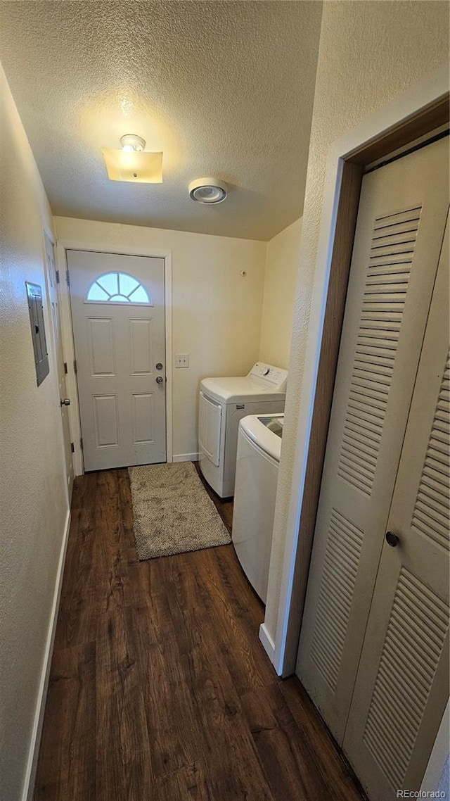 laundry area featuring dark wood-style floors, laundry area, washer and clothes dryer, and a textured ceiling