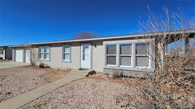 view of front of home featuring a garage, concrete driveway, and stucco siding