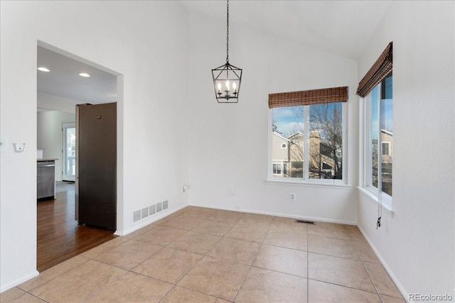 unfurnished dining area with vaulted ceiling, light tile patterned flooring, visible vents, and a chandelier