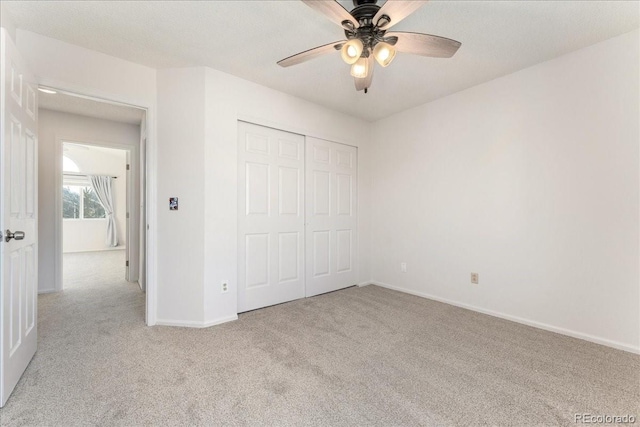 unfurnished bedroom with carpet flooring, baseboards, a closet, and ceiling fan