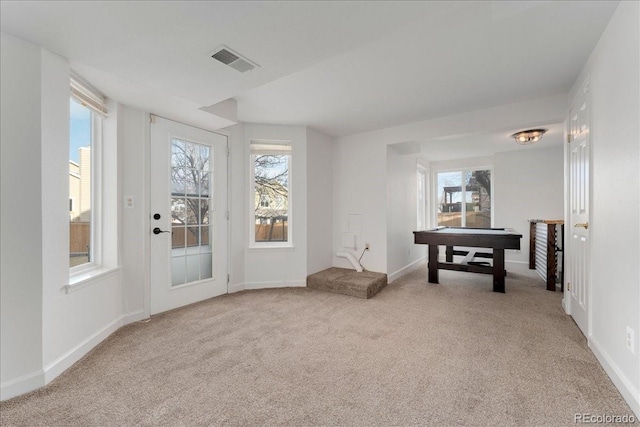 interior space featuring baseboards, visible vents, and light carpet