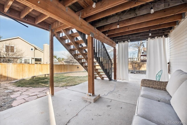 view of patio / terrace featuring stairway and fence