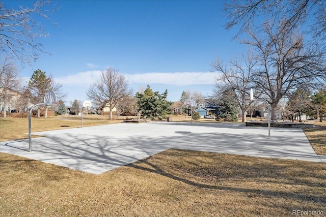 view of home's community featuring community basketball court, driveway, and a lawn