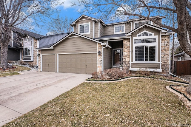 traditional-style house featuring a garage, fence, stone siding, concrete driveway, and a front lawn