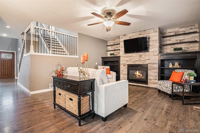 living area with stairs, a ceiling fan, a fireplace, and wood finished floors